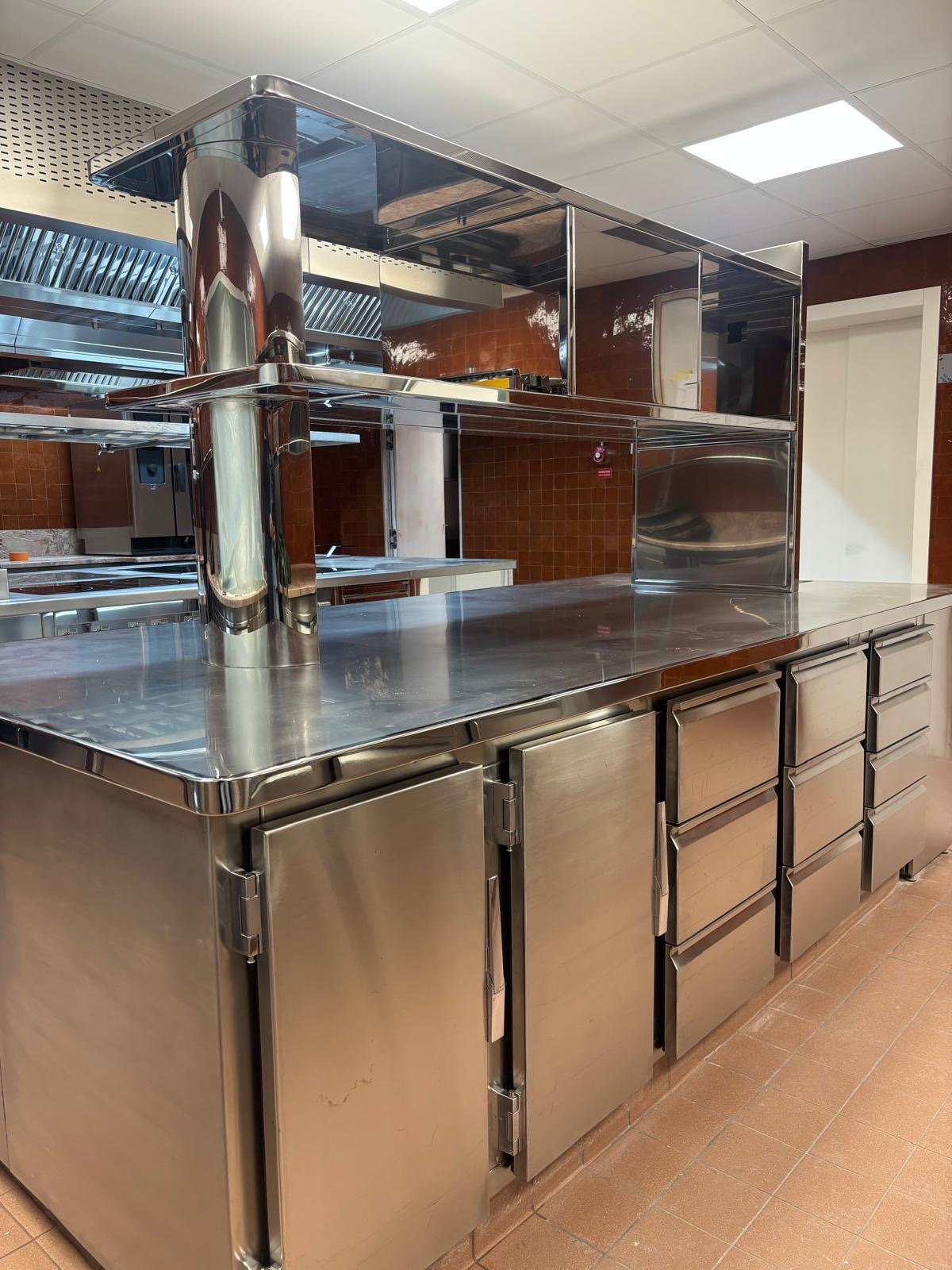 Agencement de cuisine inox haut de gamme sur mesure restaurant Agencement de cuisine professionnelle en inox avec îlot central équipé de rangements et évier intégré fabriqué sur mesure par Paris Inox