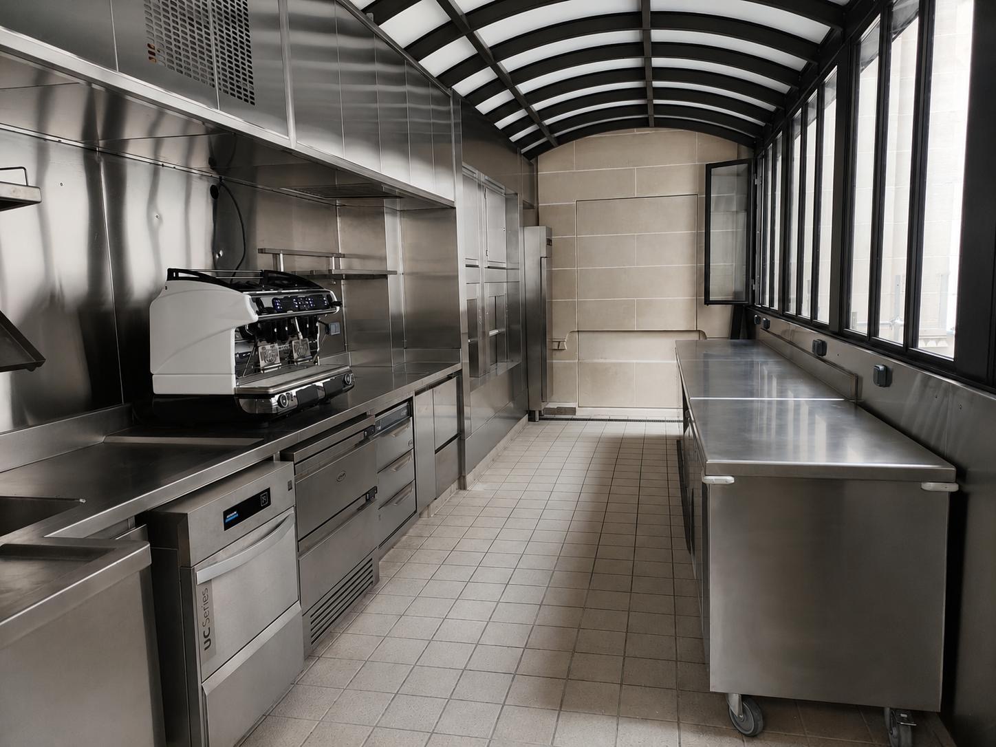Aménagement complet d'une cuisine professionnelle avec équipements et mobilier en inox sur mesure.