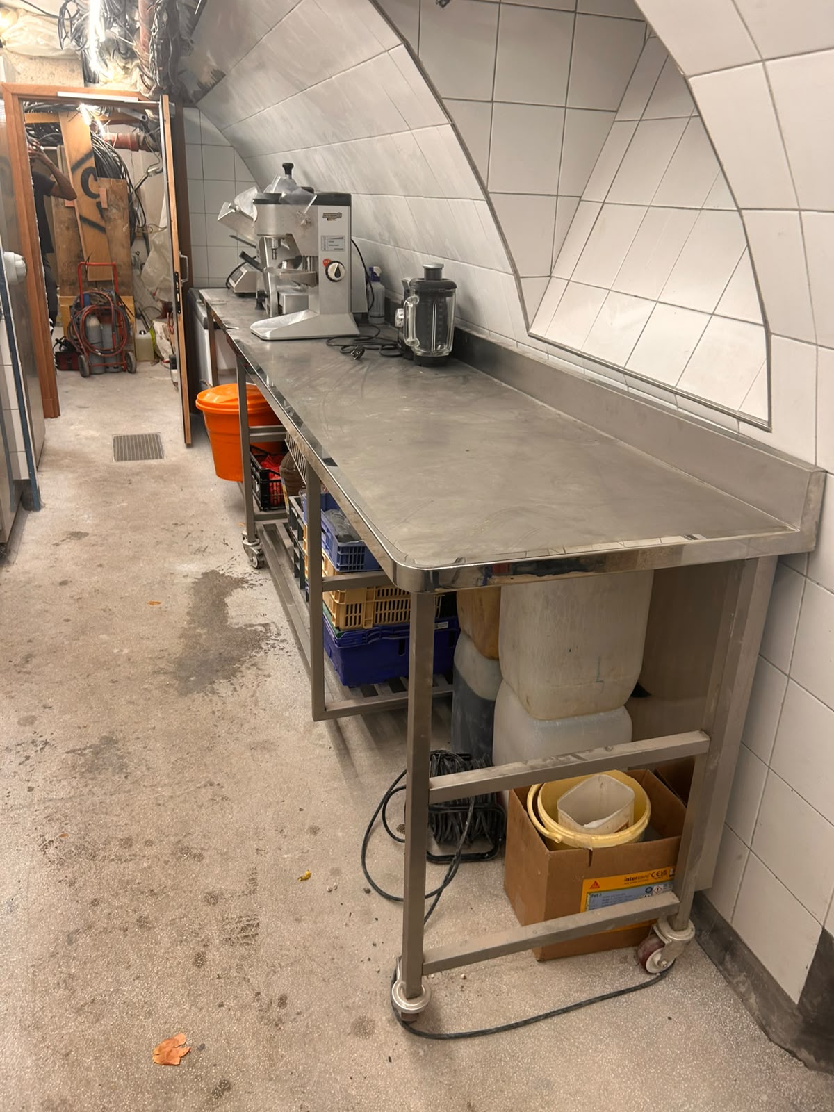 Table de travail inox sur mesure Grande table de travail en inox avec dosseret et tablette basse de rangement réalisée pour une cuisine professionnelle.
